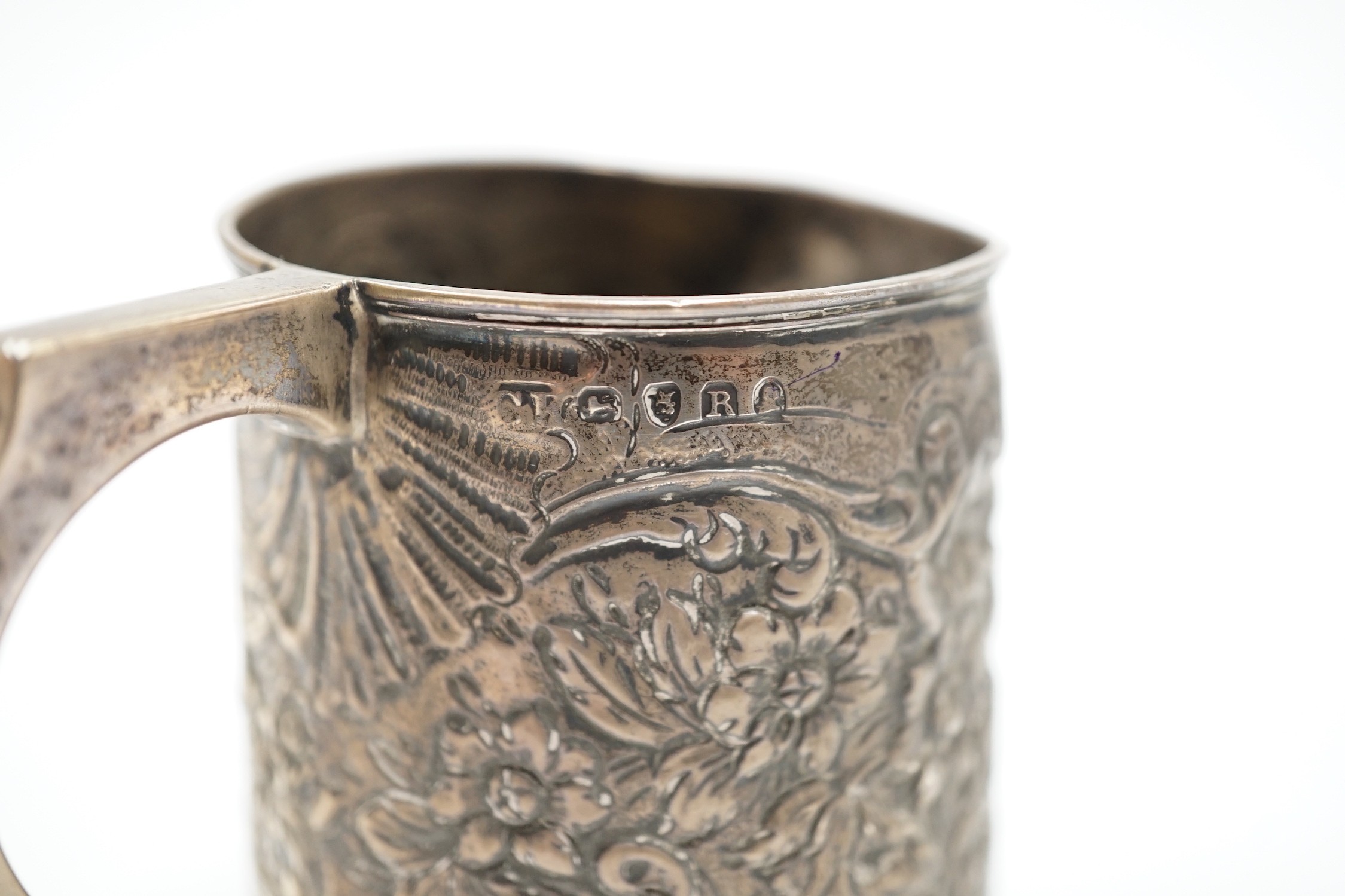 A George III silver mug, with later embossed decoration (af.), Charles Hougham?, London, 1812, height 81mm.